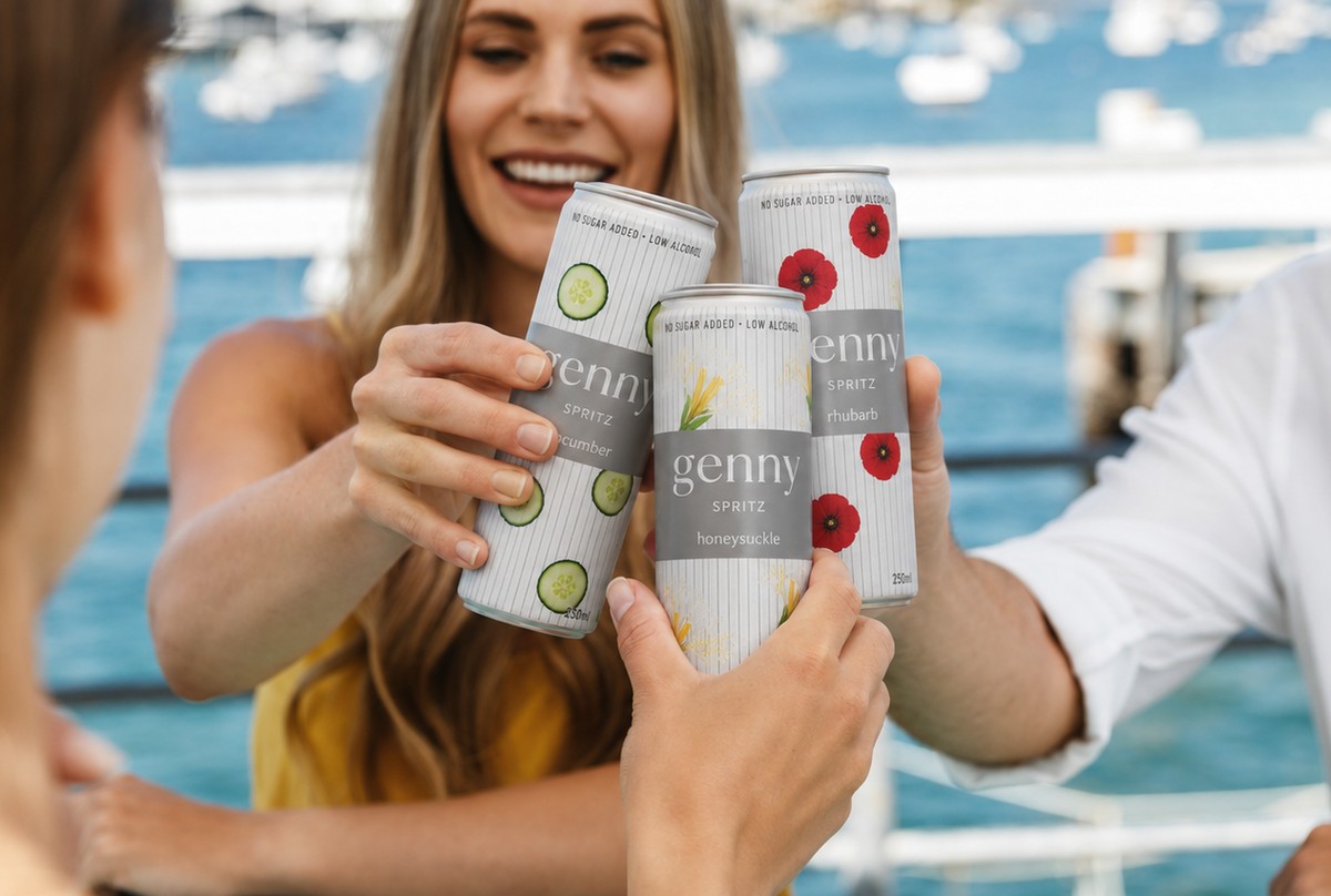 Friends toasting cans of genny spritz on a boat by the marina