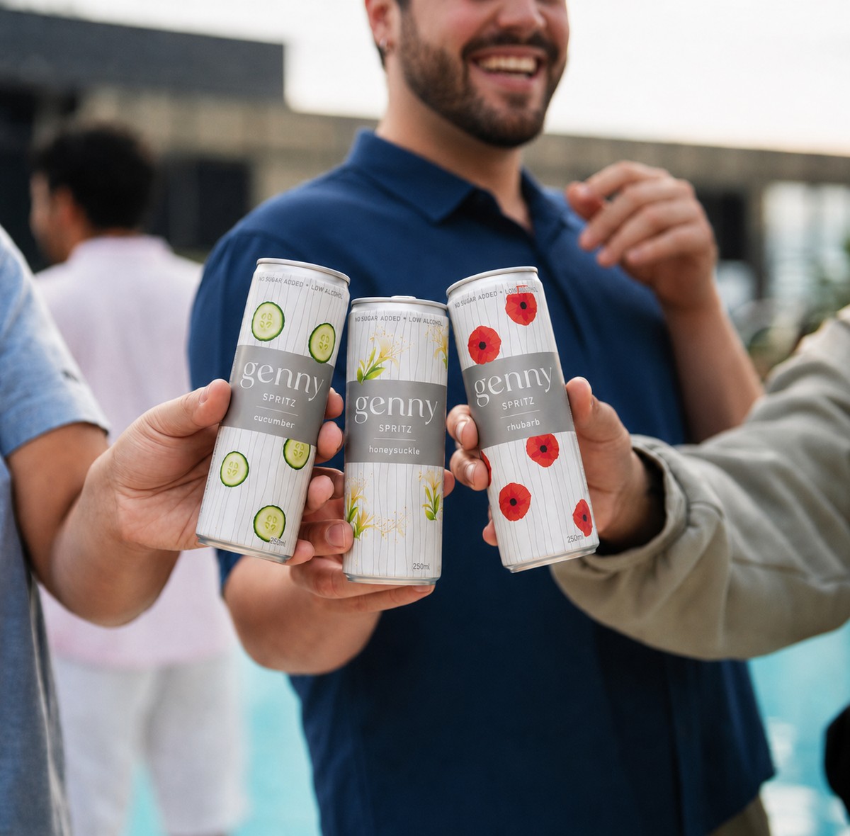 Friends toasting cans of genny spritz outdoors on a summer day