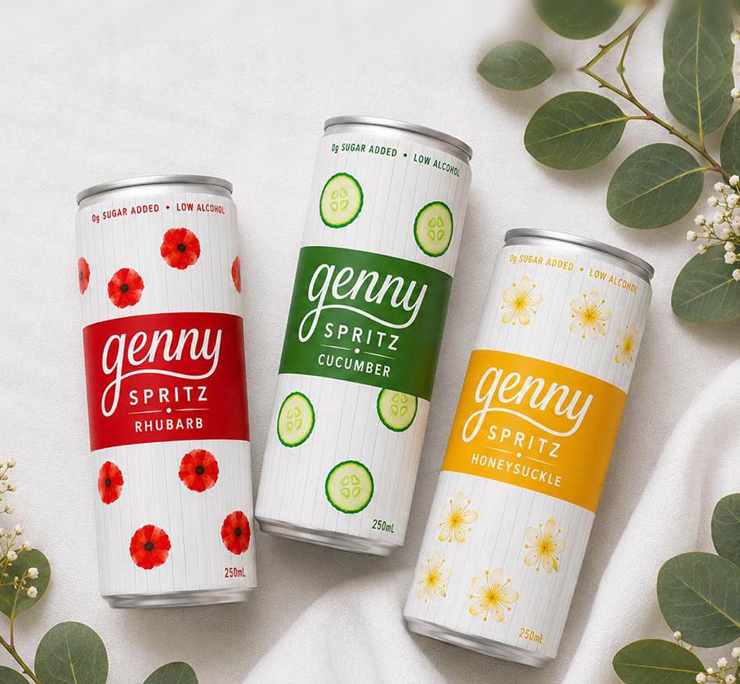 Three cans of genny spritz — honeysuckle, cucumber and rhubarb — resting on linen with eucalyptus and baby's breath.