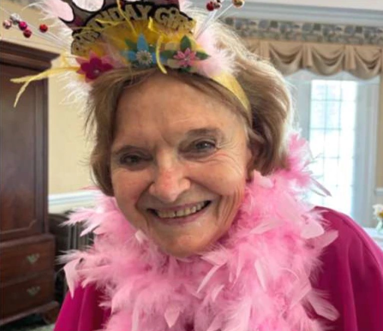 The original Genny — Natasha's mother — wearing a pink feather boa and party hat.